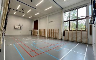 Harmaa matto liikuntasalissa taustalla puolapuut ja köydet