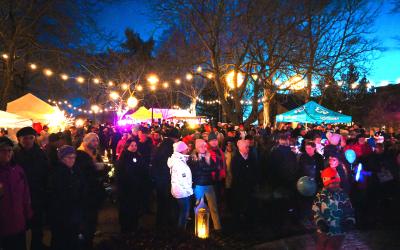 Ihmisiä katsomassa Hehkun ohjelmaa valaistussa Rauhanpuistossa.