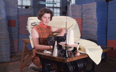 nainen ompelee ompelukoneella huopia