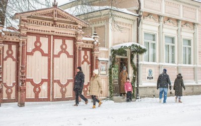 Uudenkaupungin museo ja sen hieno portti. Kuvassa ihmisiä tulossa museon ovesta ja kävelemässä kadulla