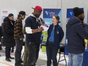 Mies haastattelee naista mikrofonilla sisähallissa.