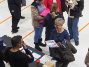 Kolme henkilöä juttelee keskenään. Taustalla muuta väkeä.