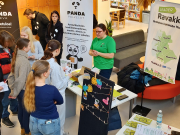 Nainen keskustelee nuorten naisten kanssa.