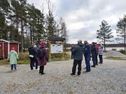Kuvassa opastaulu, ihmisiä, taustalla lintulava