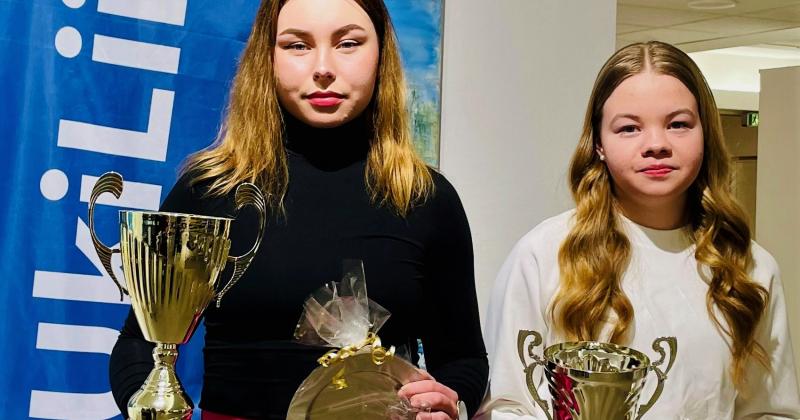 Vuoden 2022 urheilija ja junioriurheilija poseeraavat pokaalien kanssa