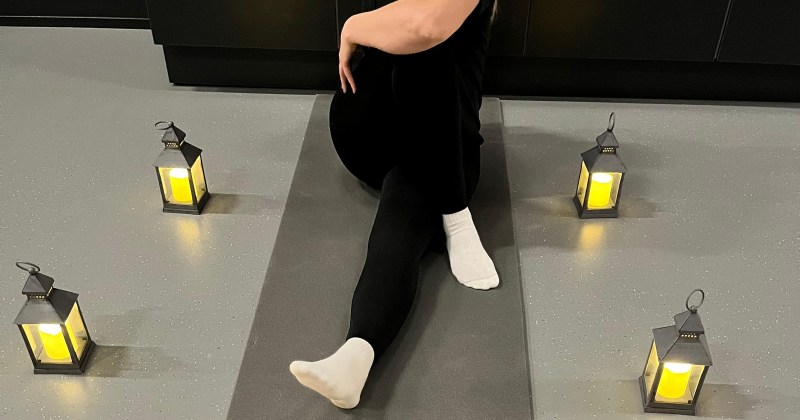 liikunnanohjaaja tunnelmavalossa istumassa lattialla