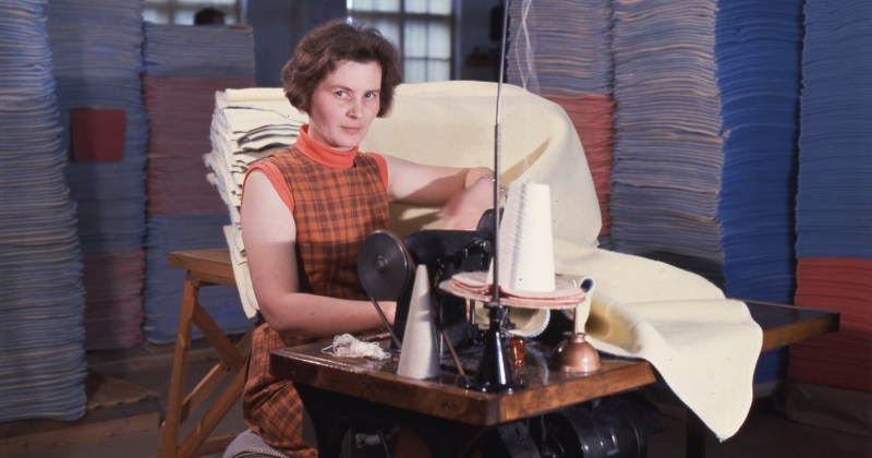 nainen ompelee ompelukoneella huopia