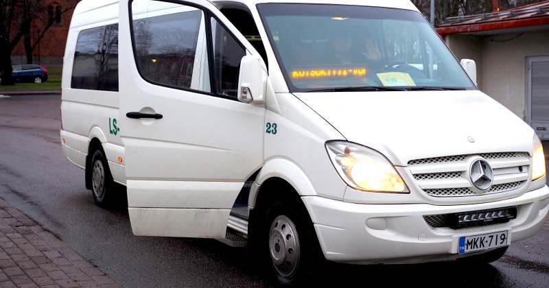 Kuvassa valkoinen vukikyydin käyttämä pikkubussi Uudenkaupungin linja-autoasemalla