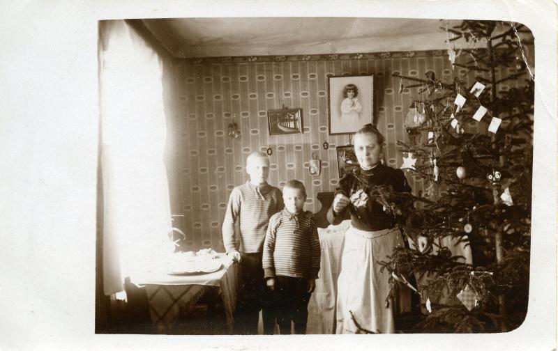 Joulukuusen vieressä nainen ja kaksi lasta 1920-luvun alussa.